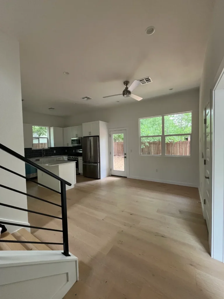 Open living area with stairs and kitchen in a new ADU at 500 Capitol Drive, Austin TX